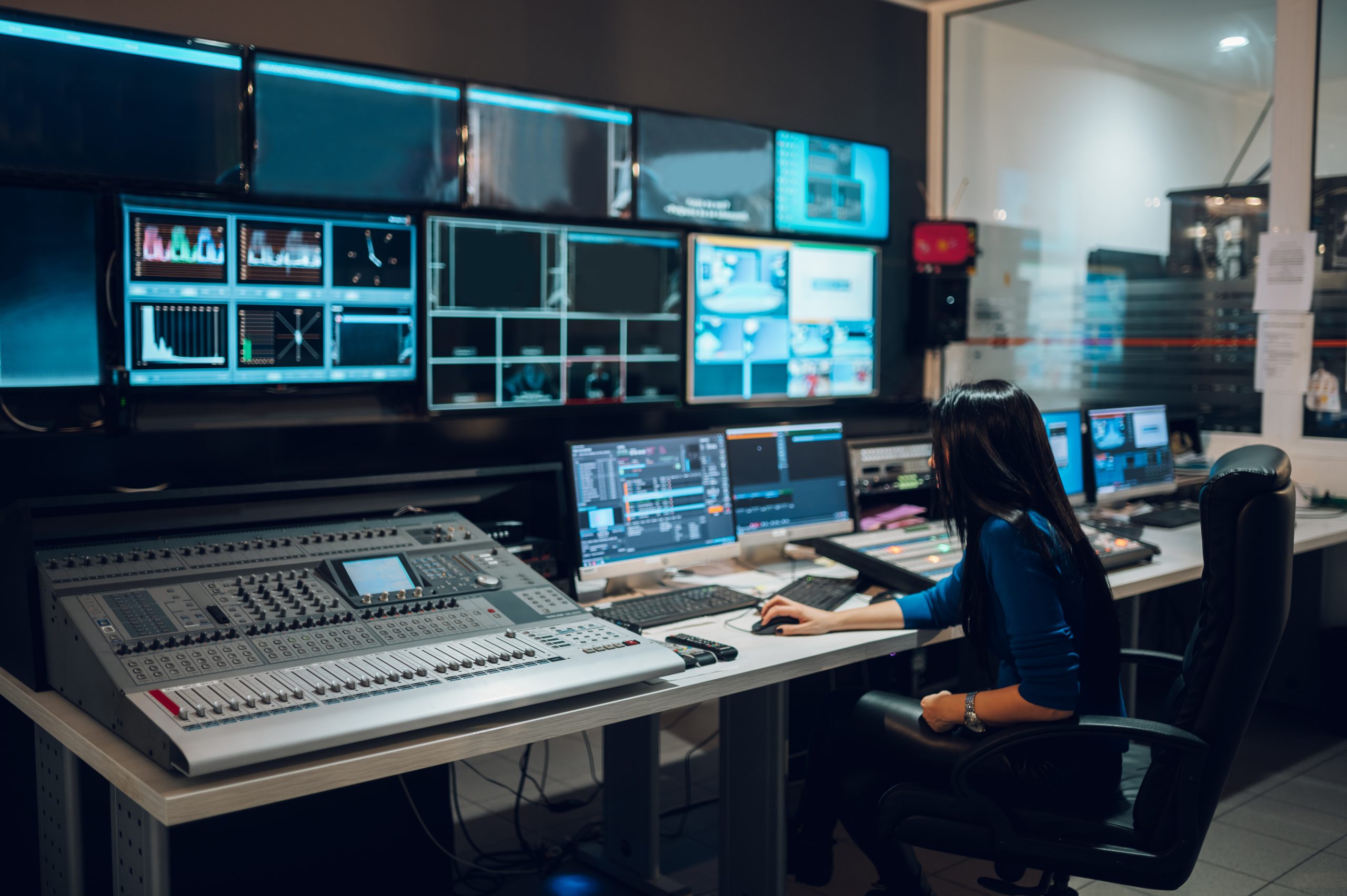 Middle aged woman using equipment in control room on a tv statio
